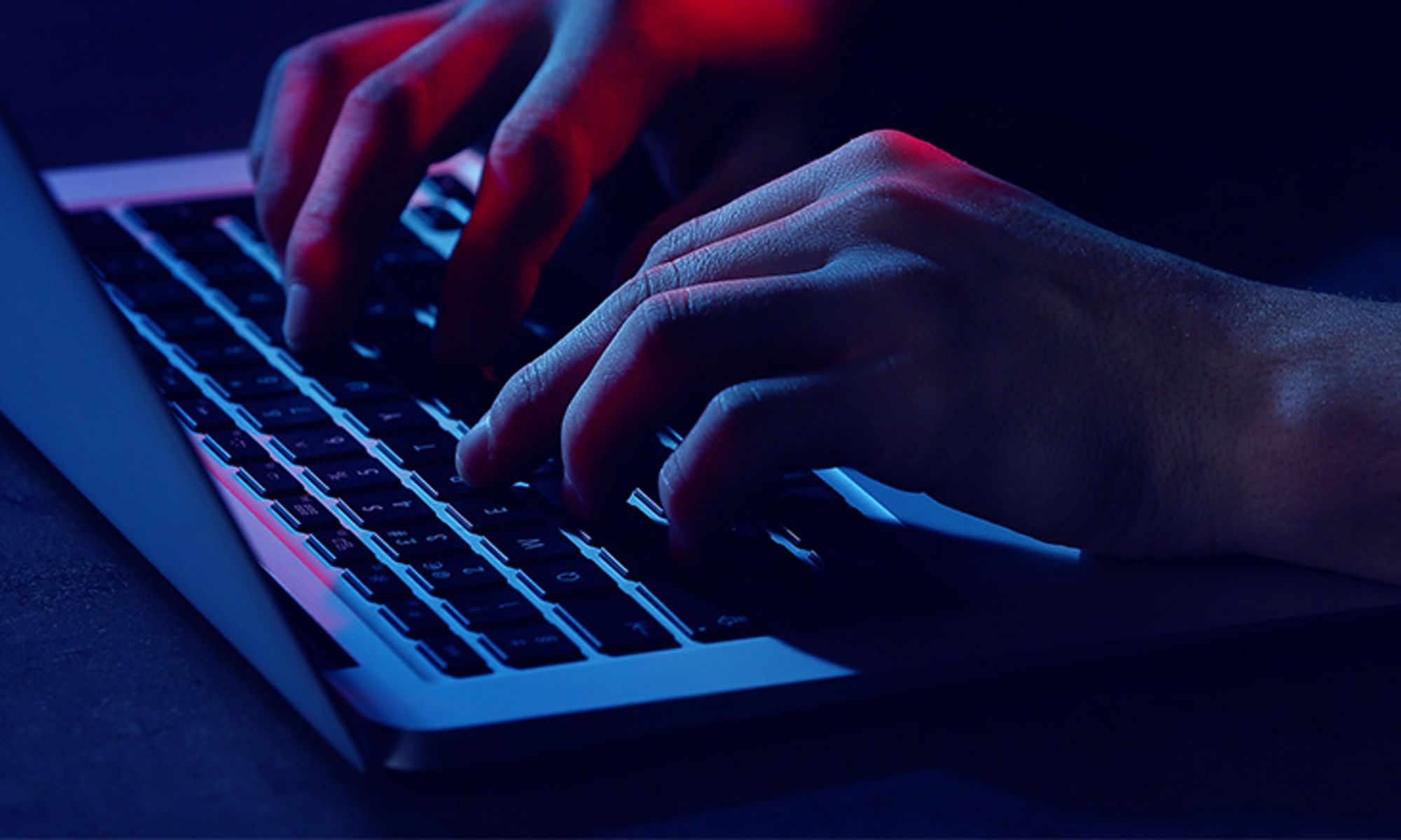 A pair of hands typing on a thing and light laptop