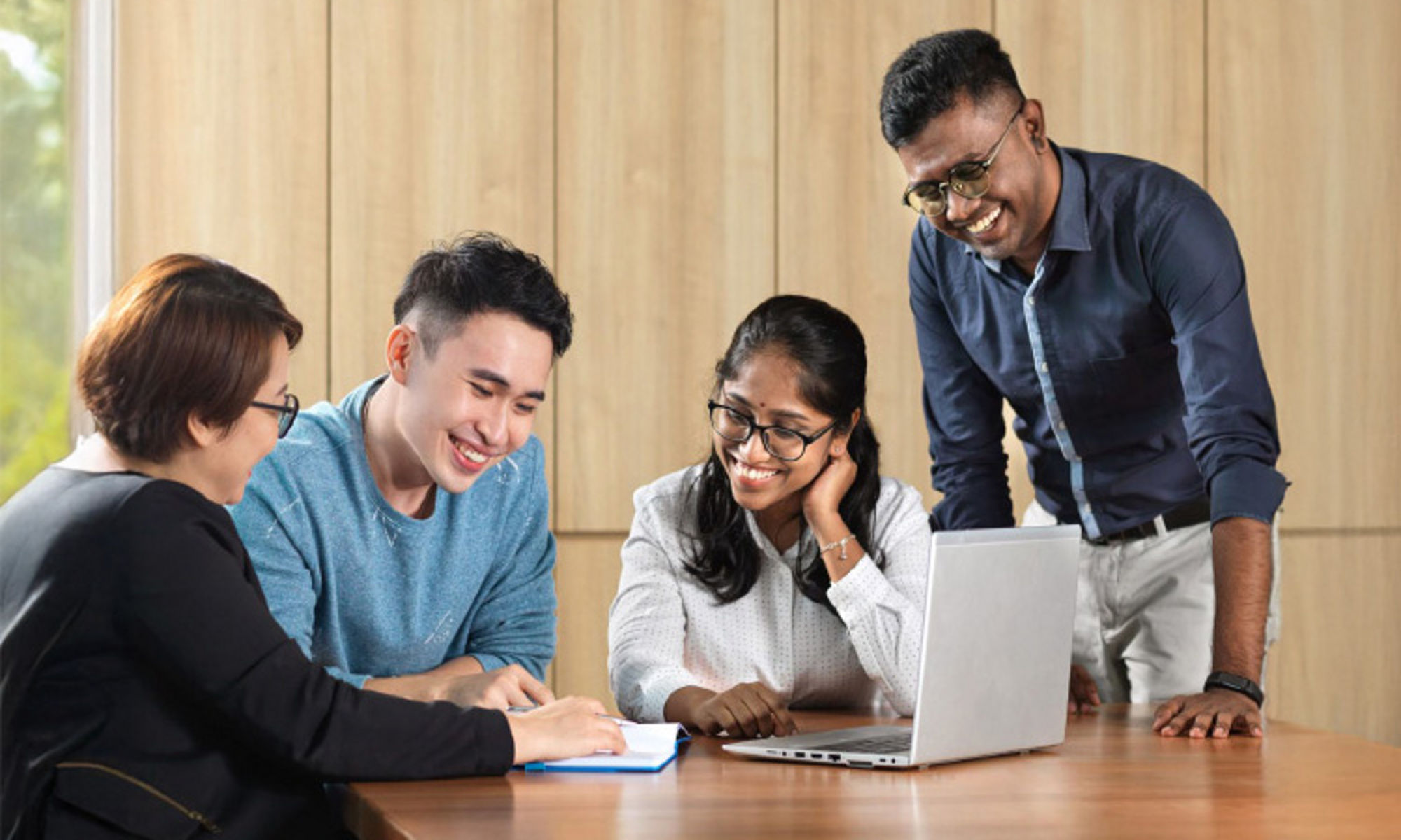 group of people having a discussion with a laptop infront of them